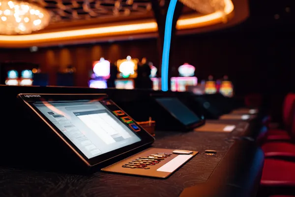 A man celebrating a winning moment on his laptop while gaming symbols float around him, capturing the excitement of PKTK games.